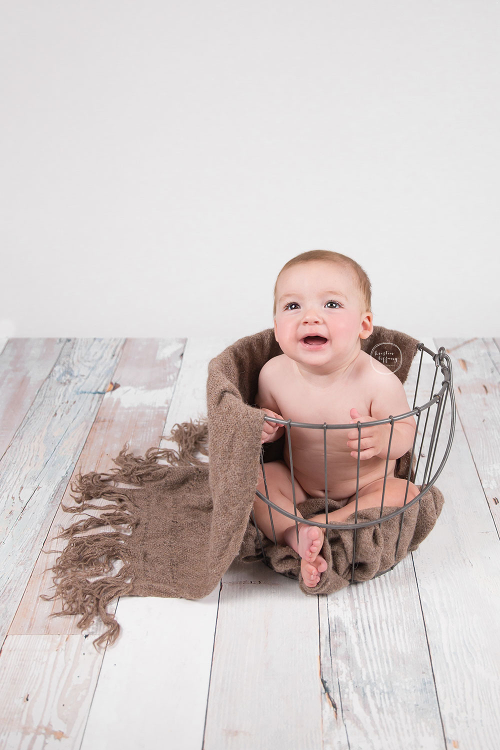 a photo of a baby boy smiling in a metal bucket
