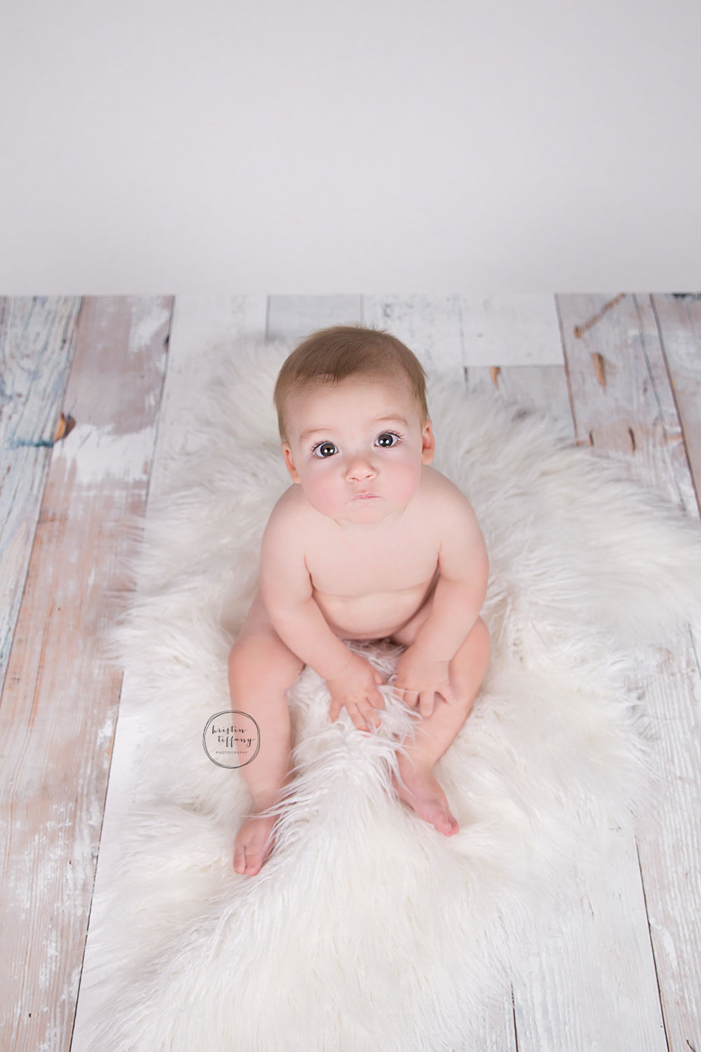 a photo of a baby boy on a fur rug