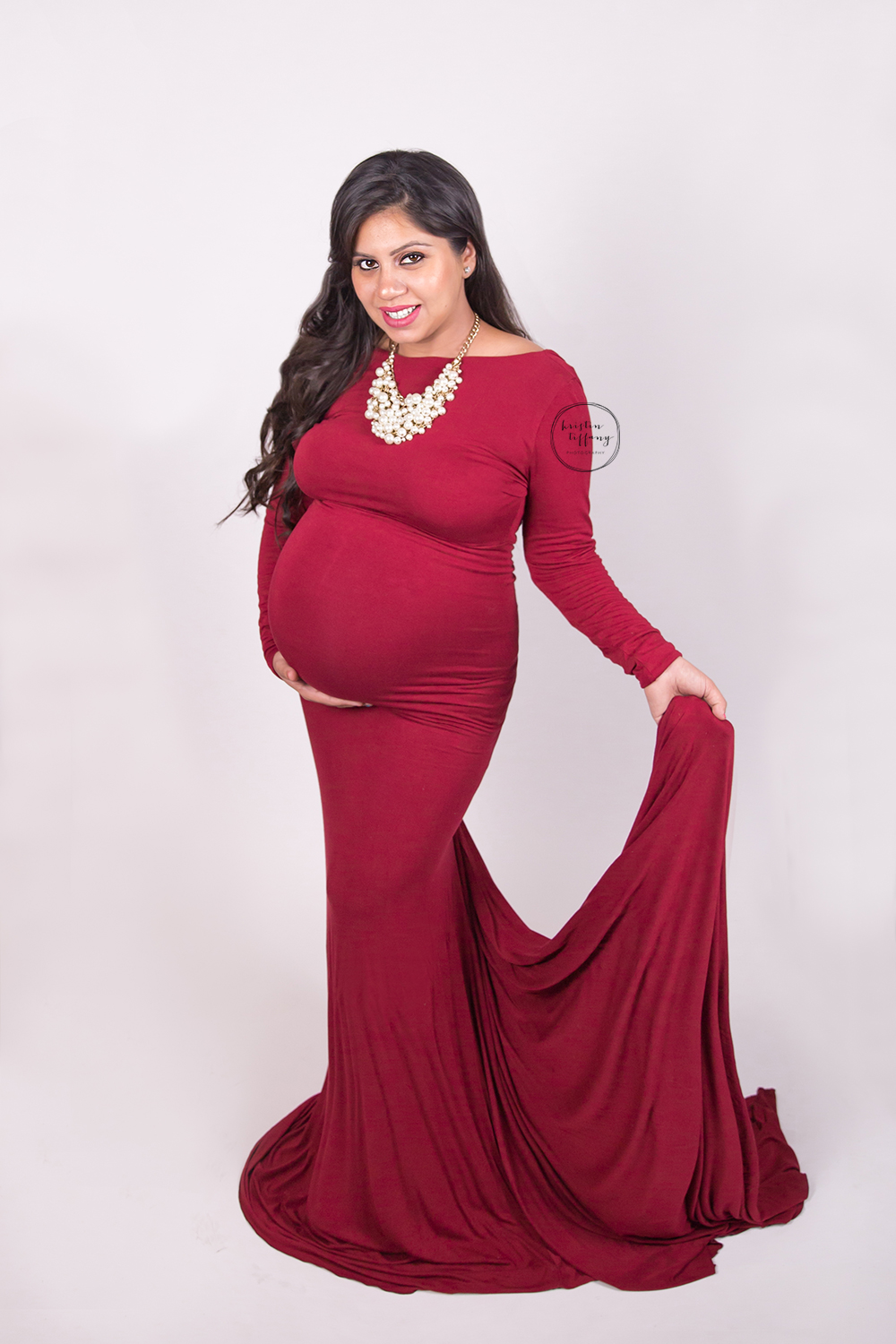a maternity photo of a woman in a red gown