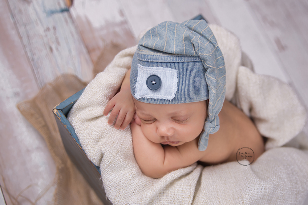 a photo of a baby boy in a wooden basket