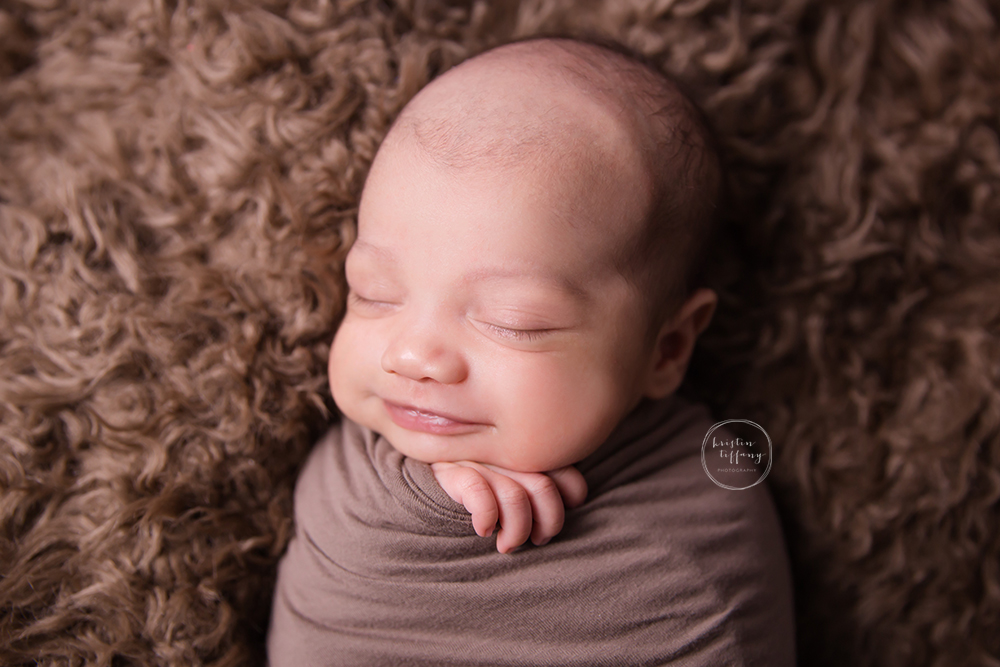 a photo of a smiling newborn baby boy