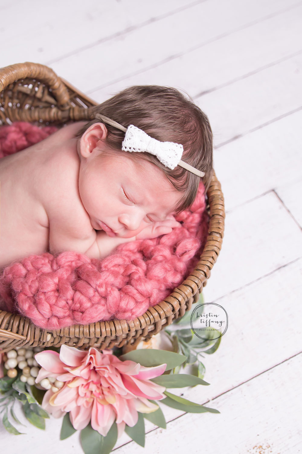 a photo of a newborn baby girl in a basket with flowers
