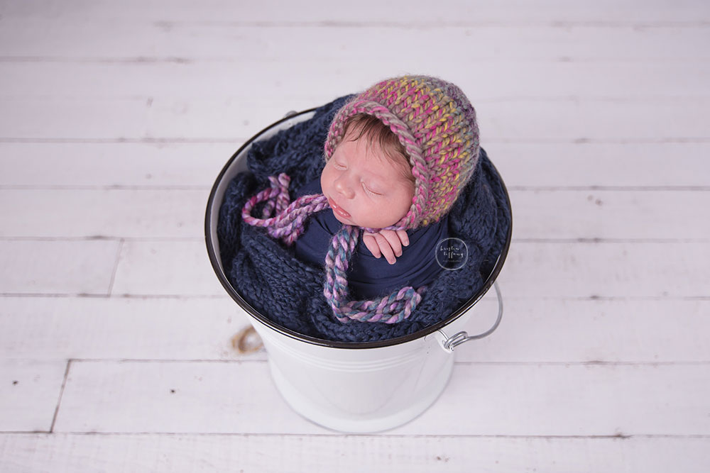 a photo of a newborn baby girl in a bucket