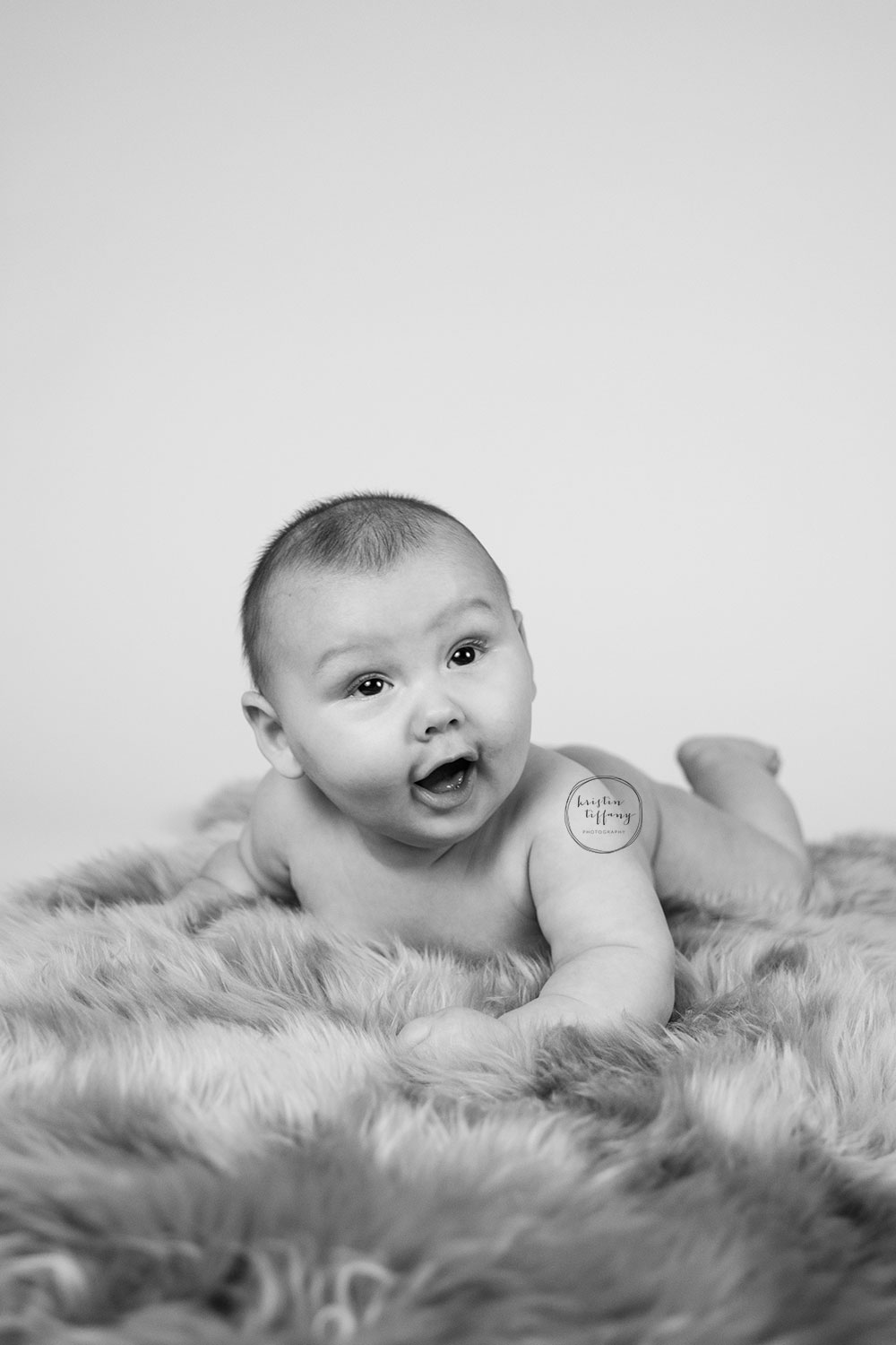 a photo of a baby boy on a fur rug