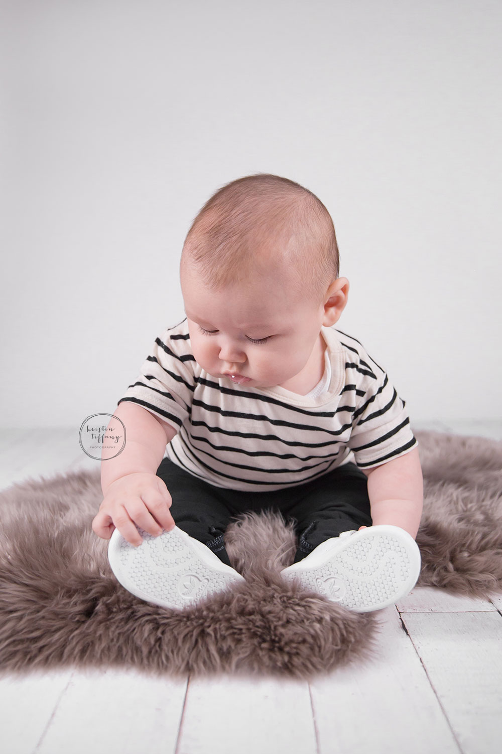 a photo of a baby boy on a fur rug