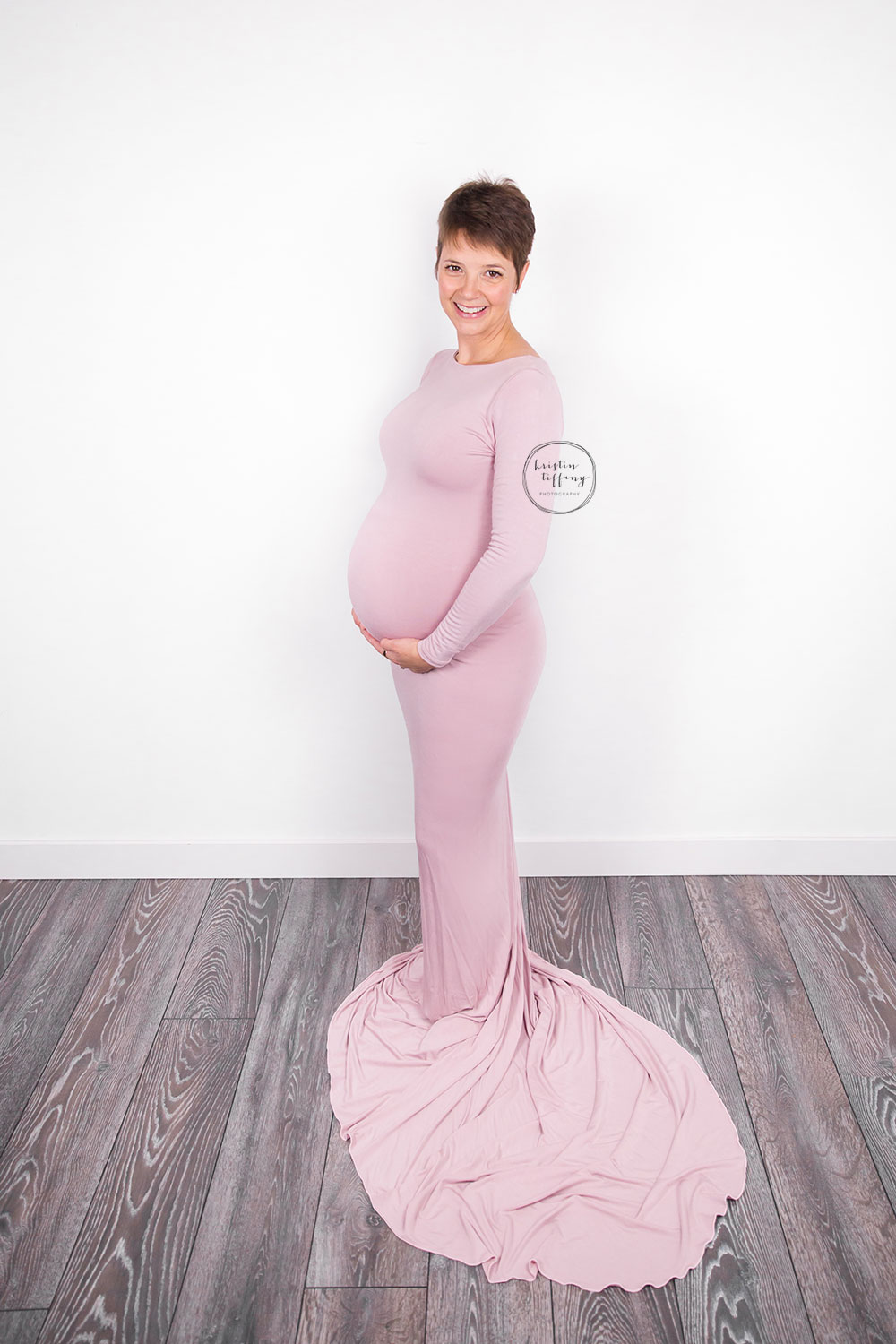 a maternity photo with a woman in a pink gown
