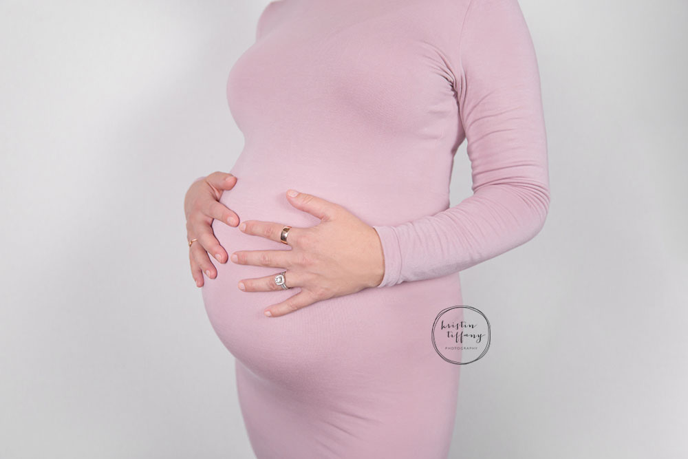 a maternity photo of a woman holding her belly
