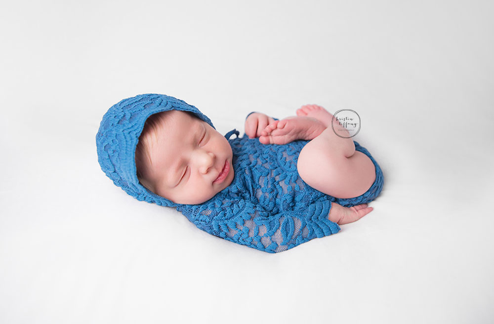 a photo of a baby girl in a blue bonnet and lace onesie