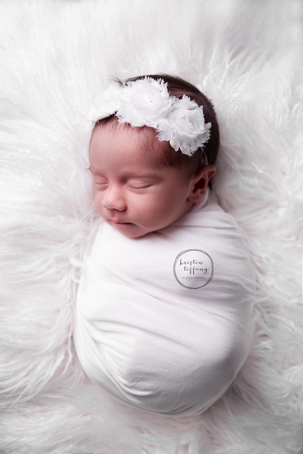 a newborn photo of a sleeping swaddled newborn baby girl