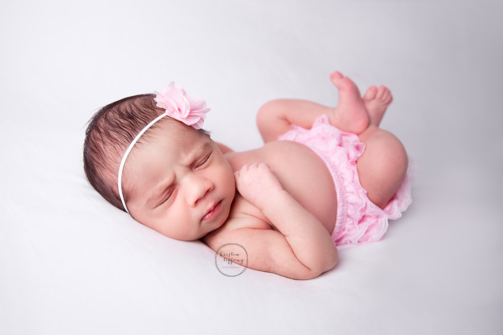 a newborn photo of a baby girl in a pink outfit