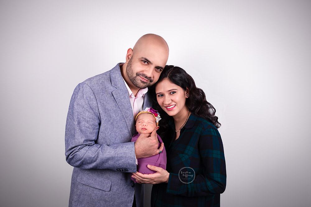 a newborn photo of a baby girl with her parents
