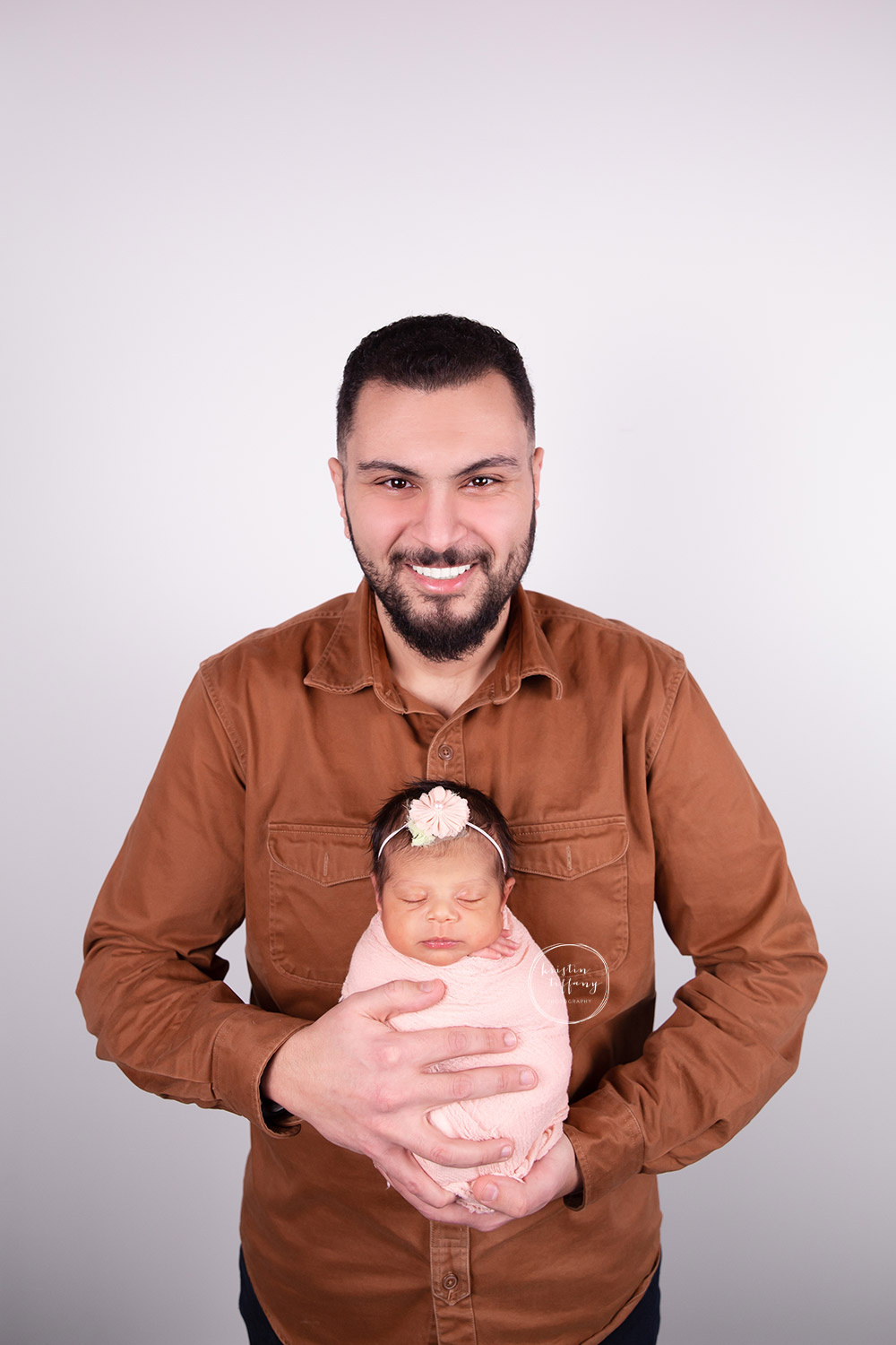 a newborn photo of a father holding his daughter