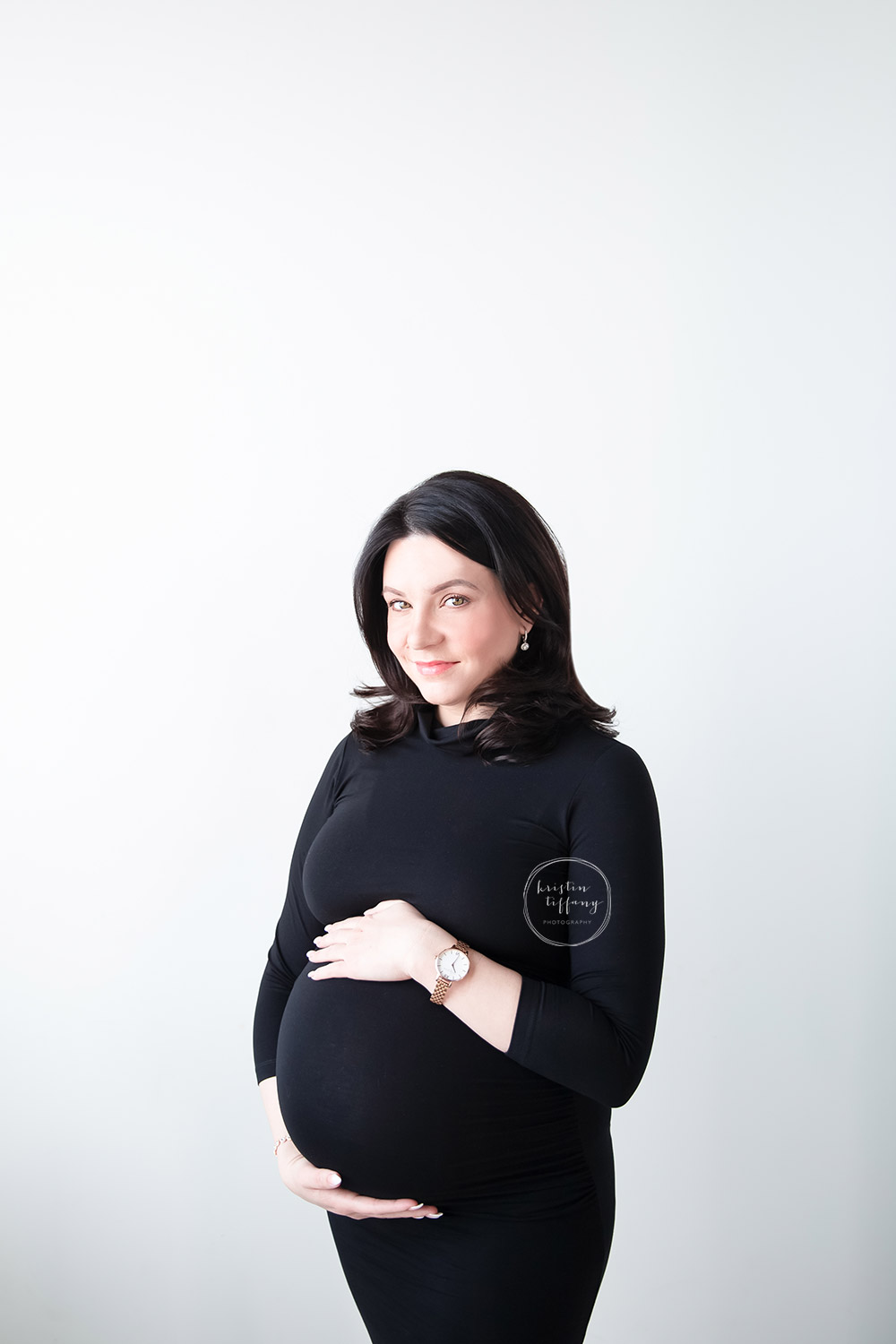 a maternity photo of a woman in a black dress