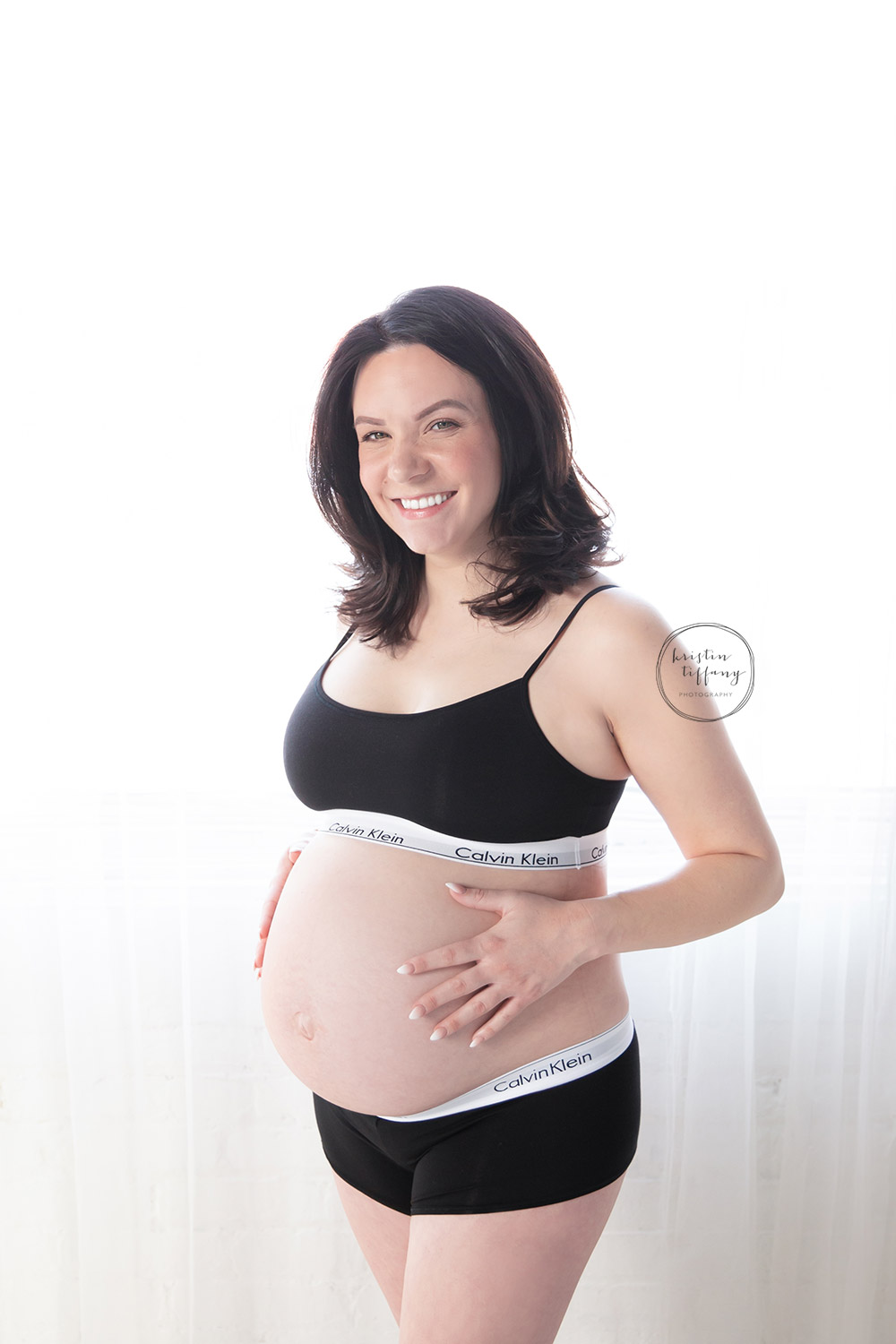 a maternity photo of a woman in her underwear
