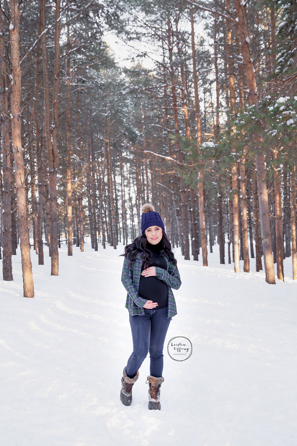 a maternity photo taken in the snowy woods