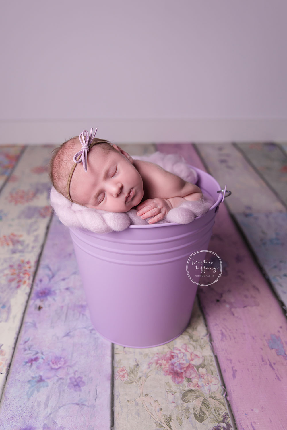 a newborn photo of a baby girl posed in a bucket