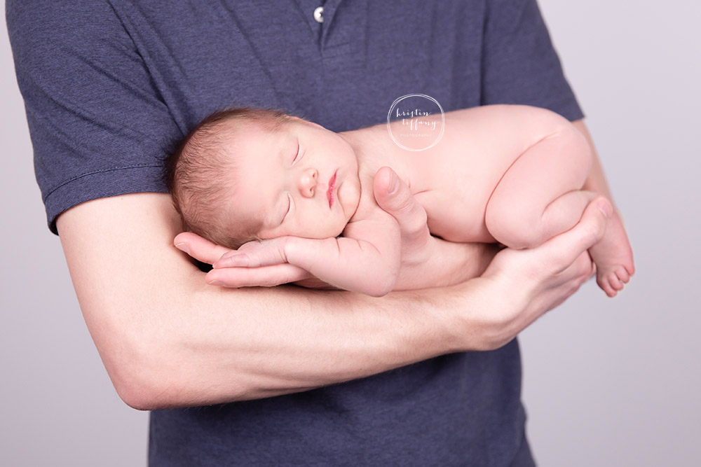 a photo of a newborn in her dad's arms