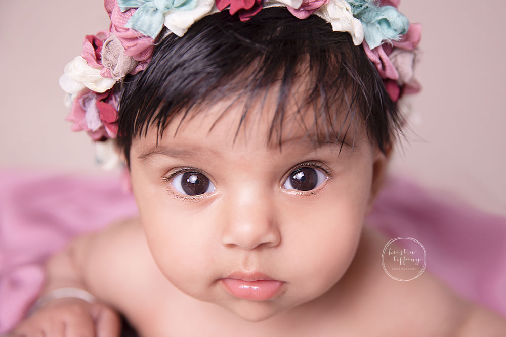 a photo of a baby girl in a floral headband