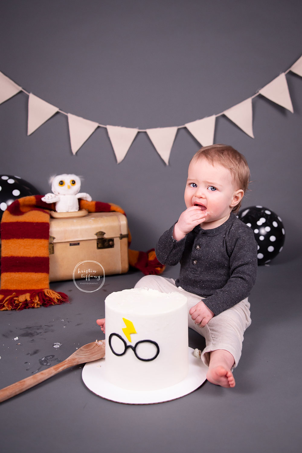a photo of a baby boy at his Harry Potter cake smash photo session