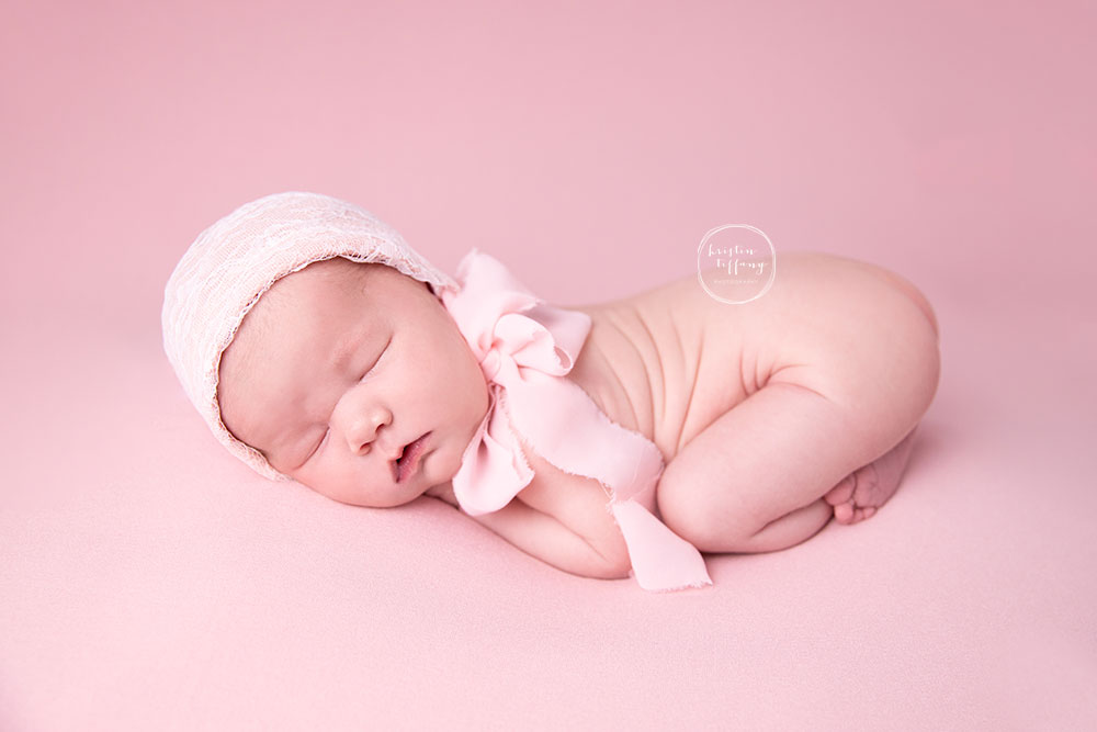 a newborn photo of a baby girl at a photoshoot