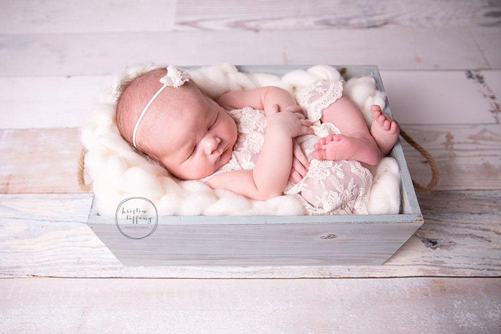 a newborn photo of a baby girl at a photoshoot