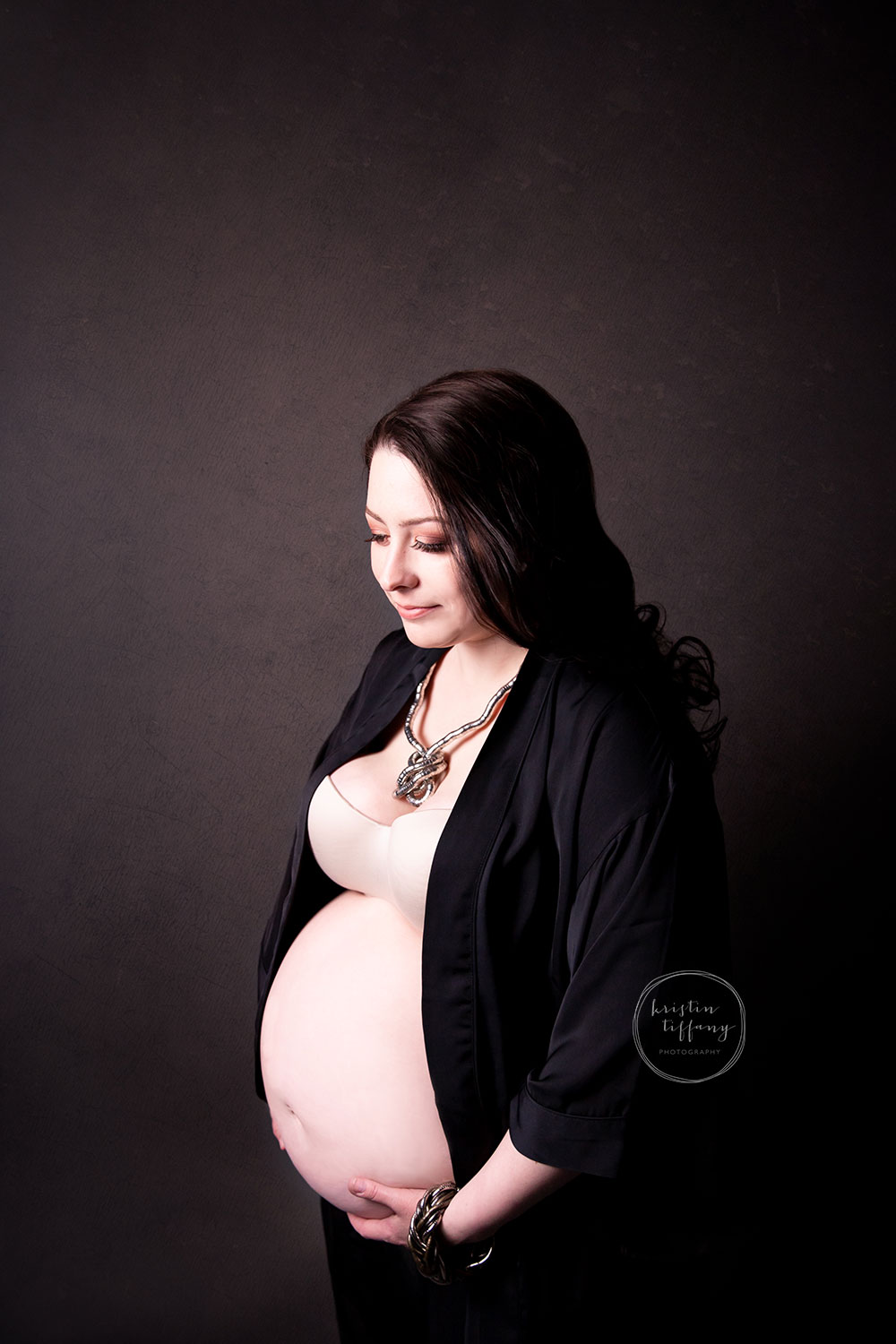 a maternity photo of a woman in a black robe