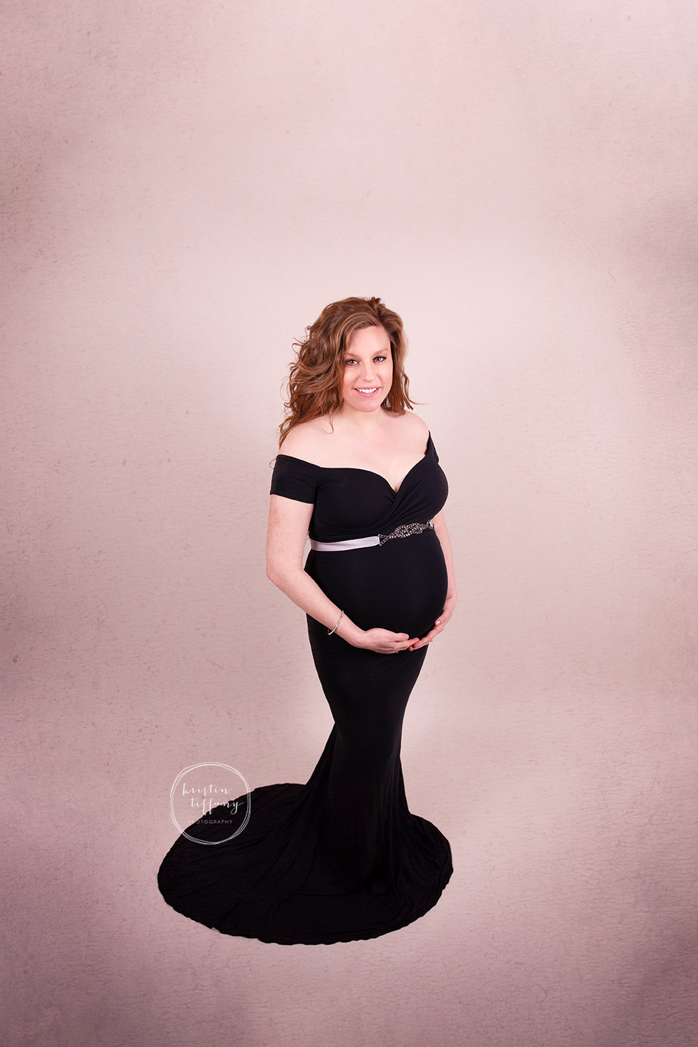 a maternity photo of a woman in a pretty dress