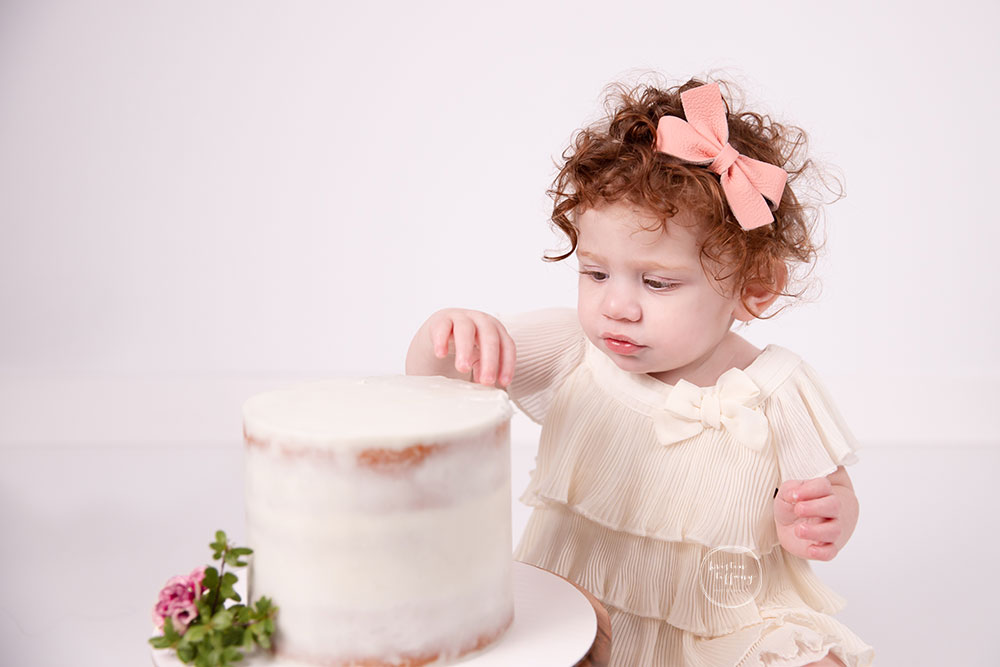 a photo of a sweet baby girl at a cake smash photo session