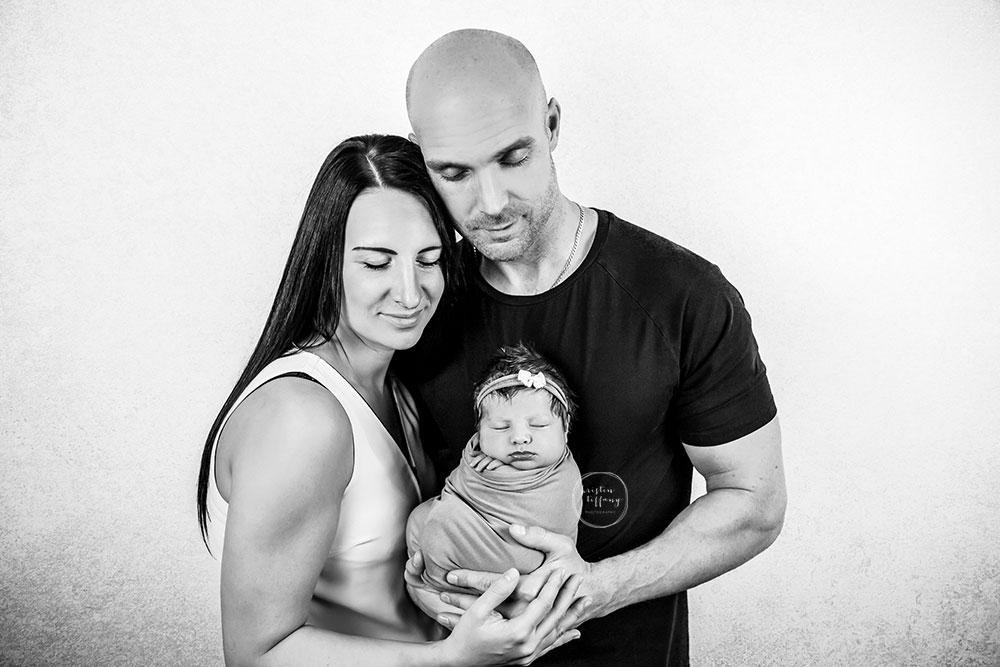 a photo of a newborn baby girl and her family at her newborn photo session