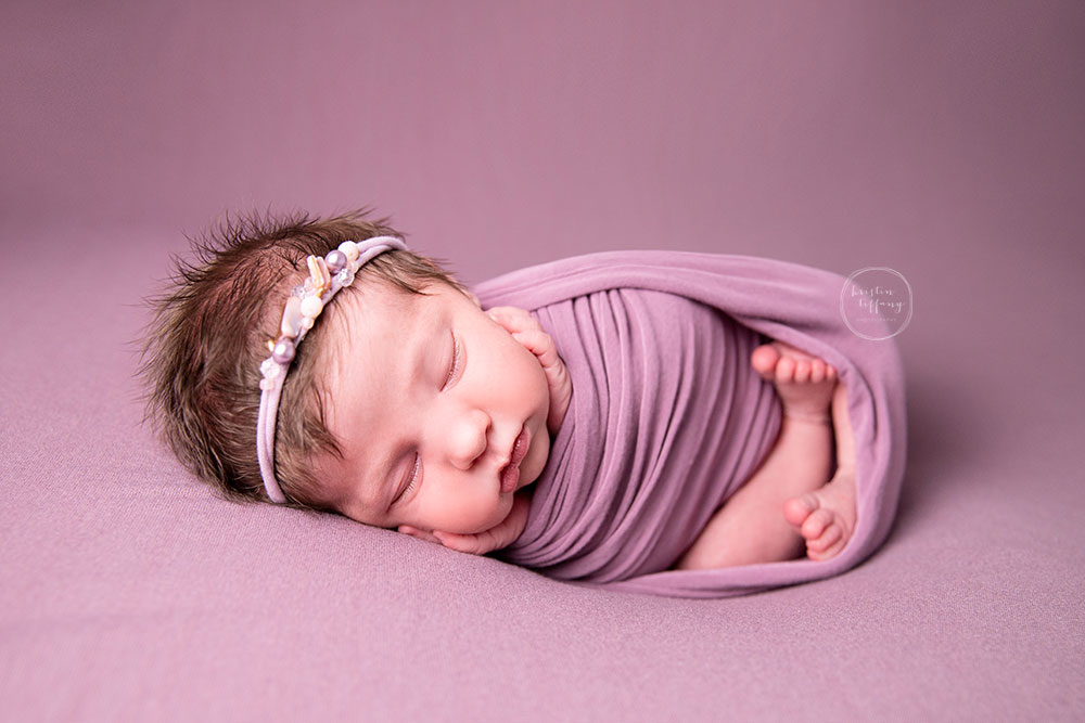 a photo of a newborn baby girl at her newborn photo session