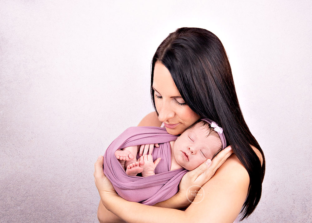 a photo of a newborn baby girl and her mom at her newborn photo session