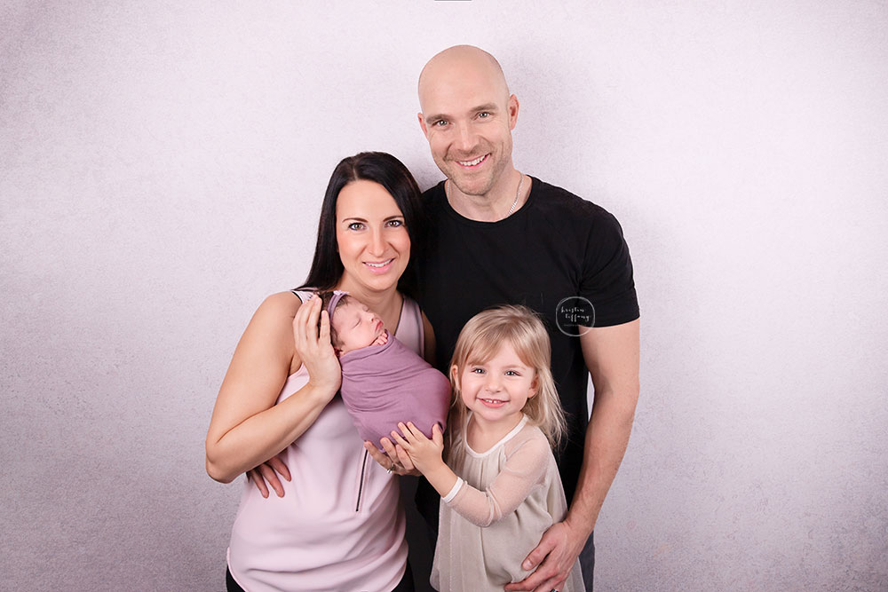 a photo of a newborn baby girl and her family at her newborn photo session