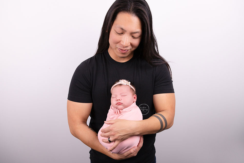 a photo of a baby girl and her dad at her newborn photo session