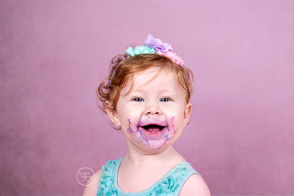 a photo of a baby girl at her unicorn cake smash photoshoot