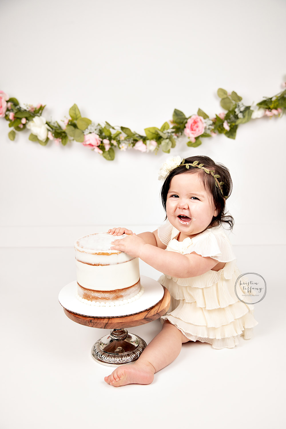 a photo of a baby girl at her cake smash session