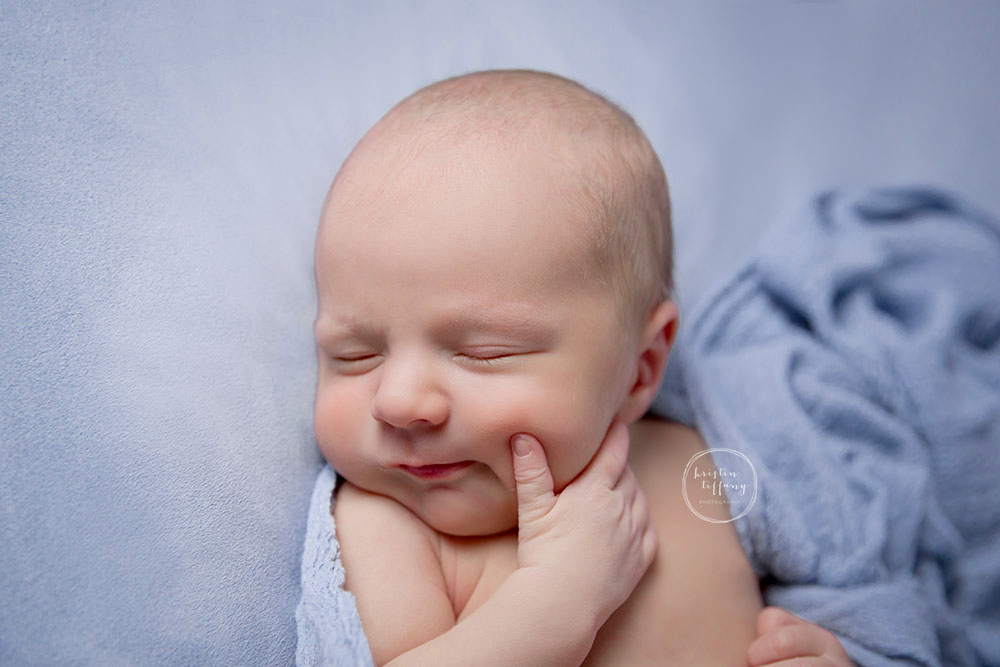 a photo of a newborn smiling with Kristin Tiffany Photography